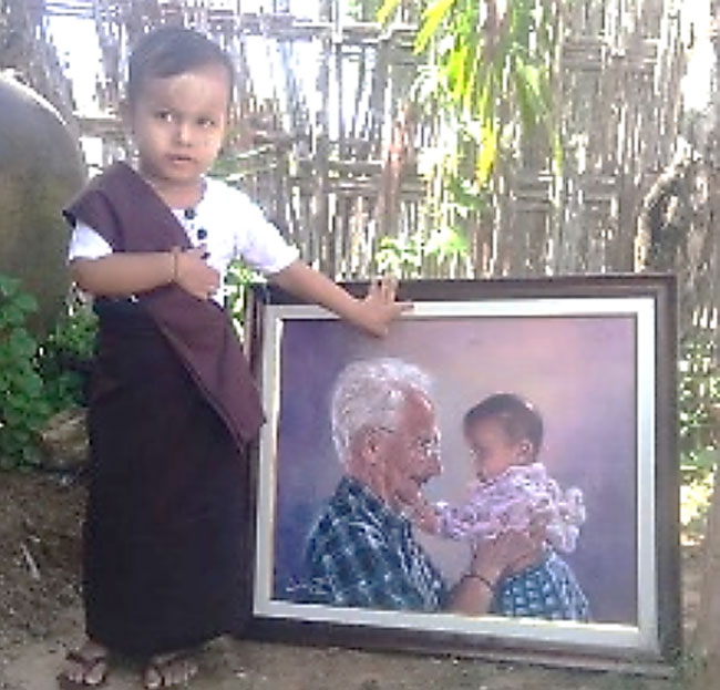 A Ngal Lay standing next to her painting.