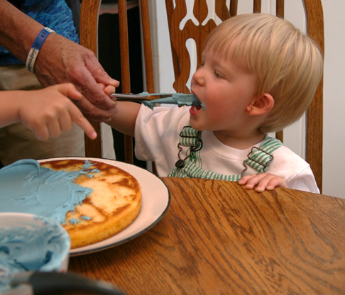 I gave Owen the knife and having observed what he saw Jack do, <br>he licks the knife while Jack's is pointing to use the knife to decorate the cake.