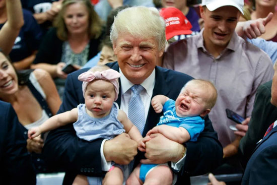 This isn’t an old guy caring for two infants; it is a photo op.